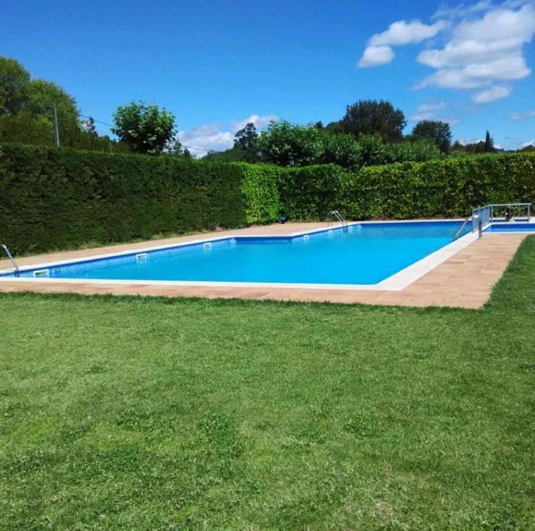 una gran piscina en un patio con césped en O Alecrin de Bouzas Ribeira Sacra, en Pereiro de Aguiar