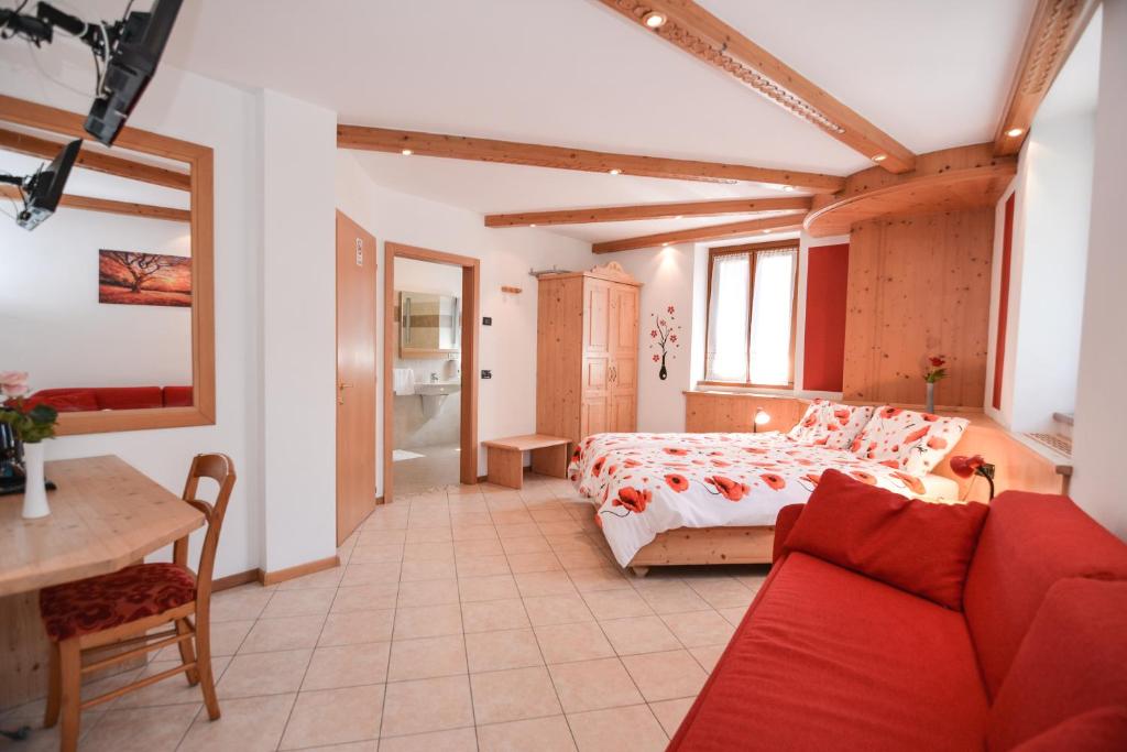 a bedroom with a bed and a red couch at Bed and Breakfast Galet in Ledro