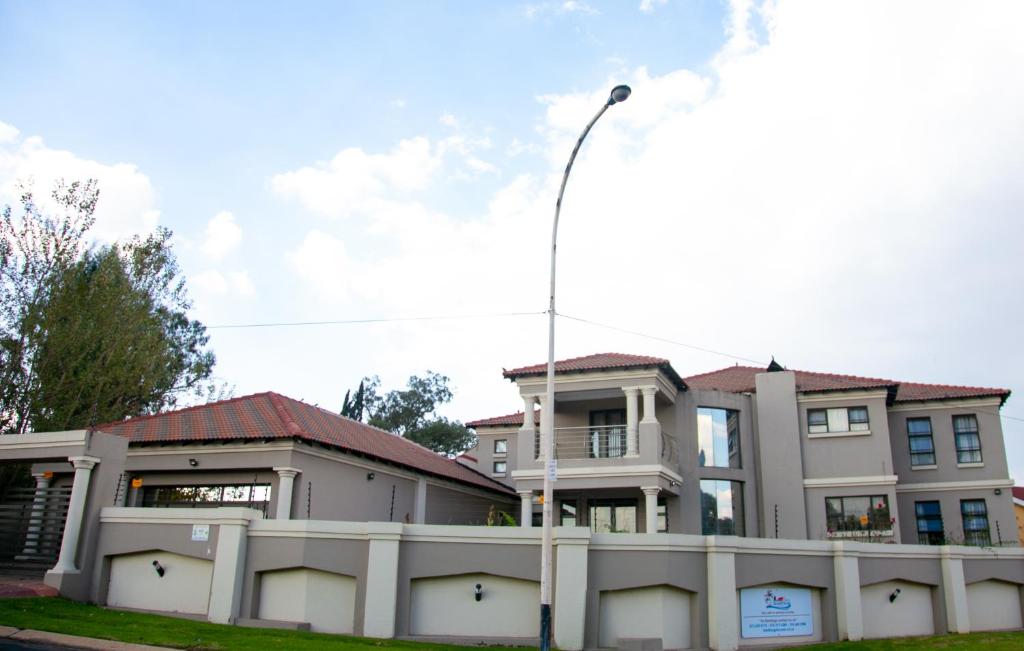 a house with a white fence and a street light at ANGELOCEAN GUEST HOUSE in Witbank