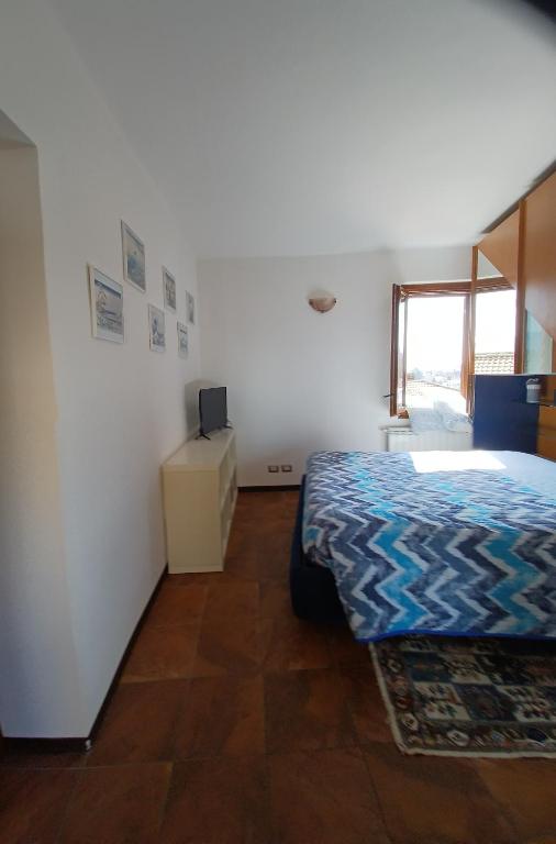 1 dormitorio con 1 cama y TV en Luminoso tra i rami del Lago di Como, Sormano, en Sormano