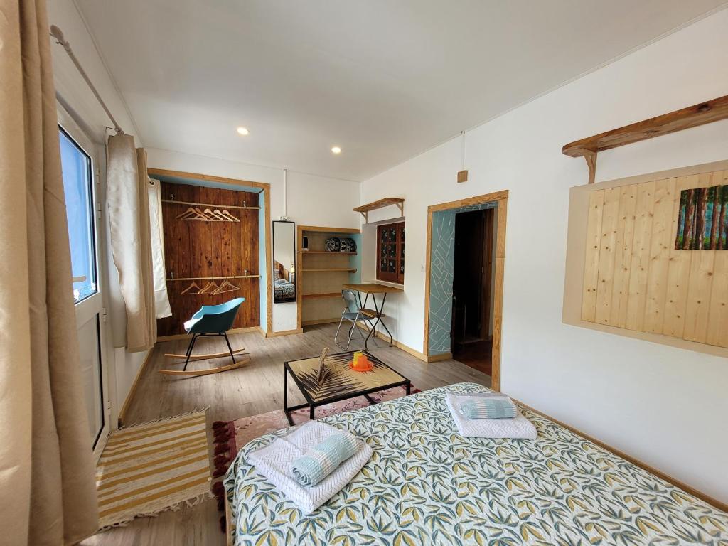 a bedroom with a bed and a table in a room at The Handmade House Azores in Porto Formoso
