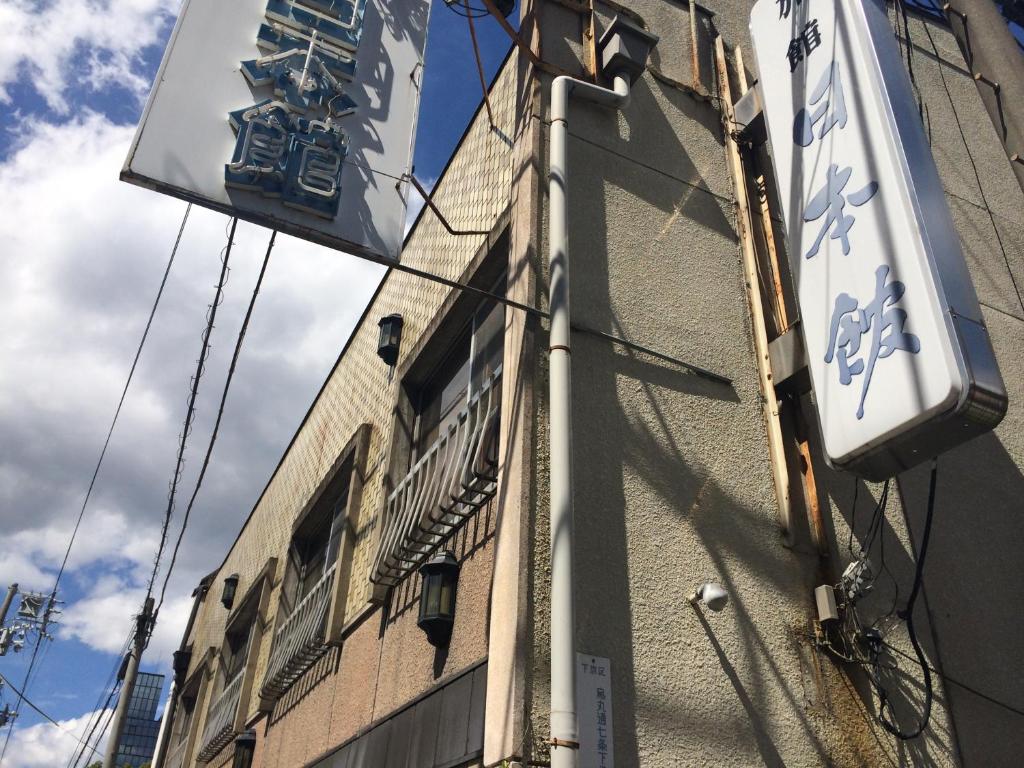 ein Schild an der Seite eines Gebäudes in der Unterkunft Nihonkan in Kyoto