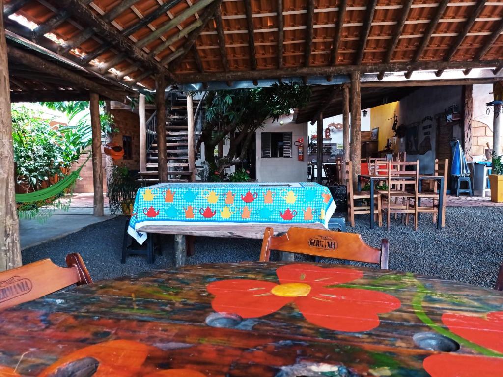 a patio with a table and chairs and a table with flowers on it at Pousada Menina Moça in Olímpia