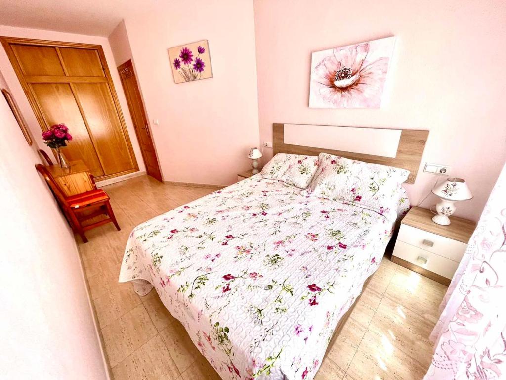 トレビエハにあるTorrevieja comfortable apartmentの小さなベッドルーム(花柄のベッドカバー付)
