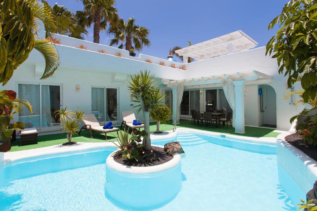 a villa with a swimming pool and a house at Villa 82 in Corralejo