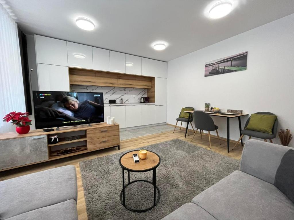 a living room with a couch and a flat screen tv at CityApartment in Sofia