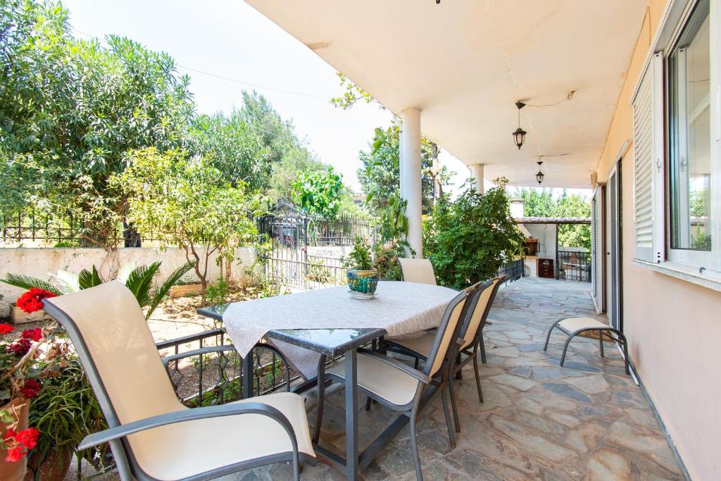 eine Terrasse mit einem Tisch und Stühlen in der Unterkunft Sunset House Near Athens Airport in Spáta