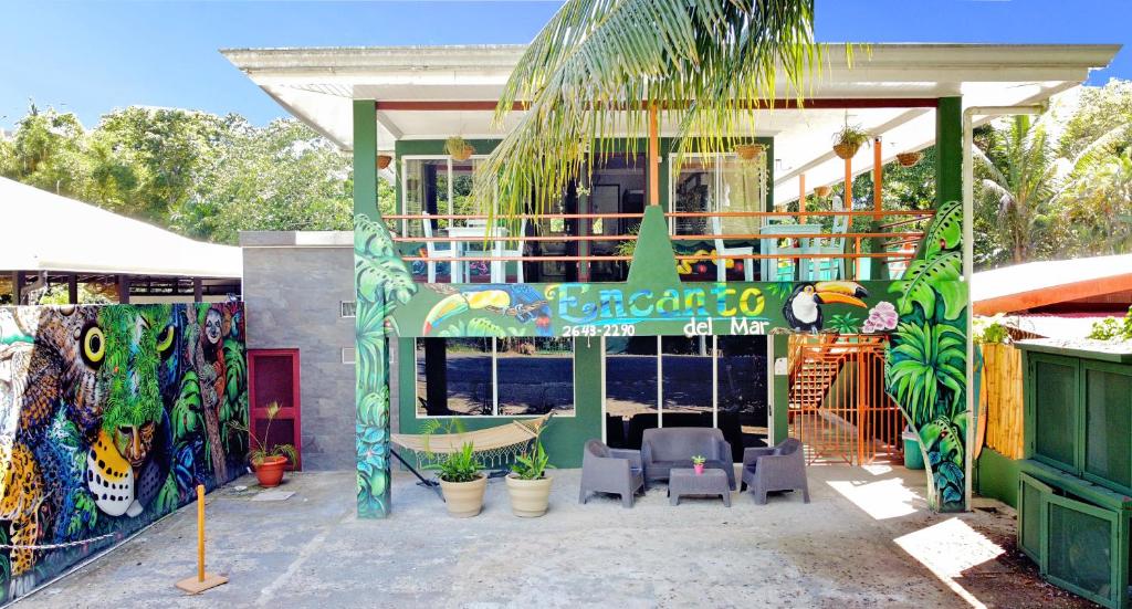 un edificio con un restaurante de marisco con sillas frente a él en Encanto Del Mar Hotel en Jacó