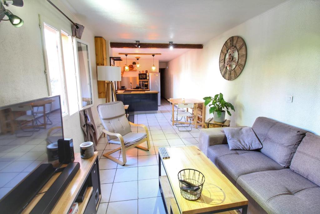 salon z kanapą i stołem w obiekcie Appartement proche toutes commodités w mieście Tulon