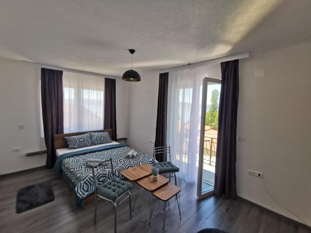 a bedroom with a bed and a table and a window at GOPO Guesthouse Elshani in Ohrid