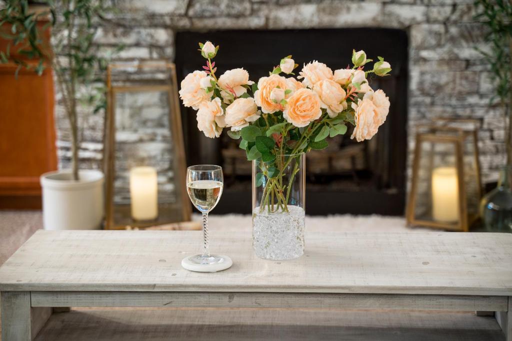 un vaso di fiori e un bicchiere di vino su un tavolo di Luxe Quiet Townhouse w/Parking/Pool/By Dollywood a Pigeon Forge
