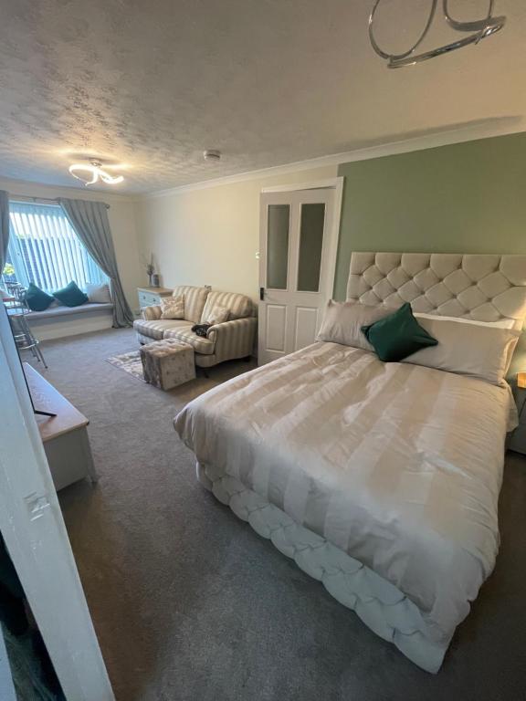 um quarto grande com uma cama grande e um sofá em The Nest, Livingston em Livingston