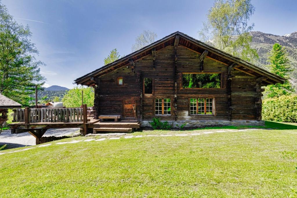 une cabane en rondins avec une véranda et une terrasse dans l'établissement 4BR Traditional Chalet BBQ + Fireplace + View, aux Houches