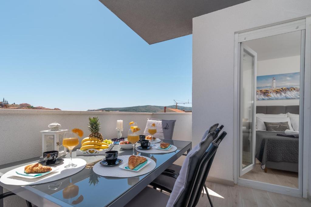 une salle à manger avec une table et de la nourriture et une vue sur l'océan dans l'établissement Apartment Toma, à Seget Vranjica