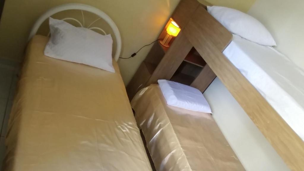 מיטה או מיטות בחדר ב-Quarto Individual para 3 Pessoas em AP Compartilhado