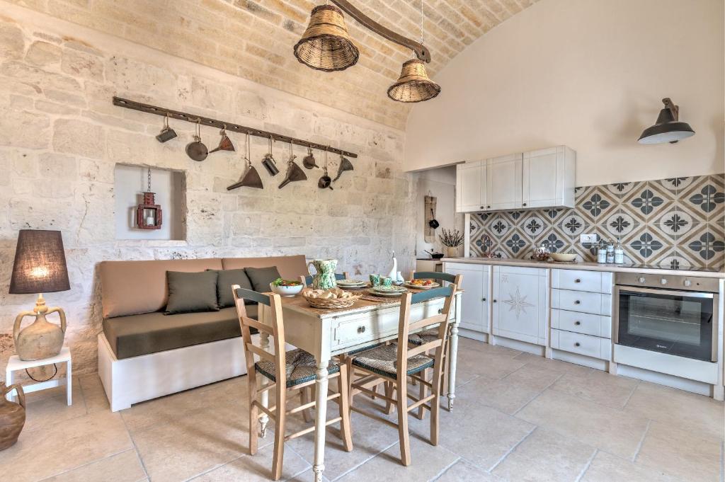 una cucina e una sala da pranzo con tavolo e sedie di Borgo Altobello a Cisternino