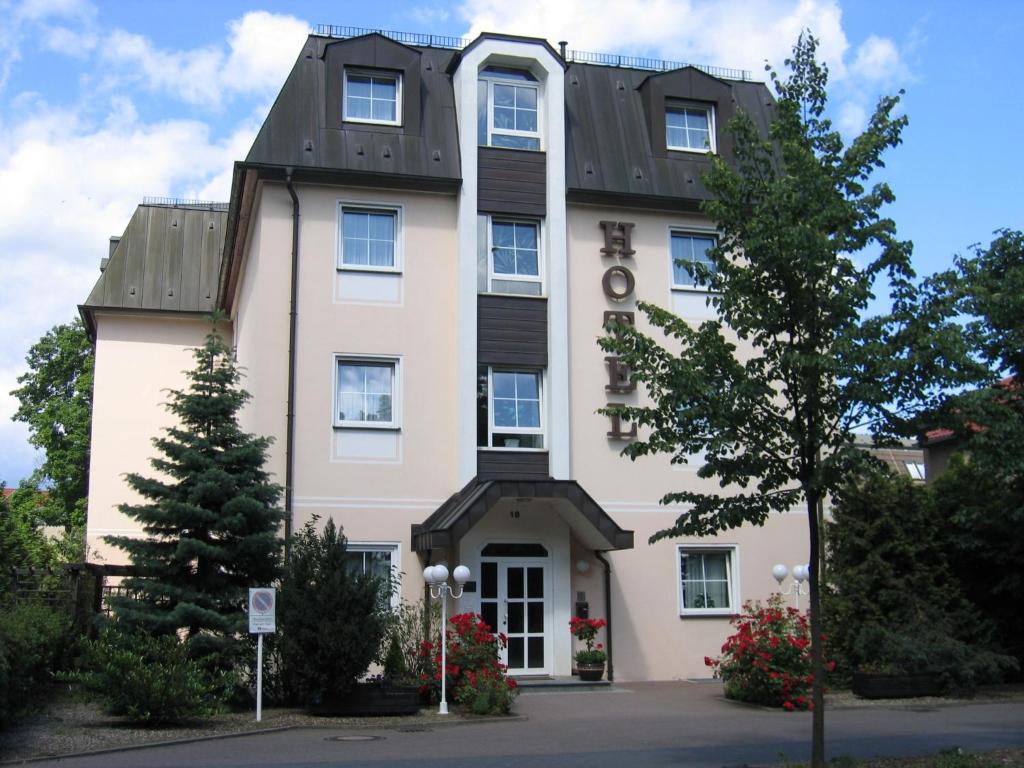 duży biały budynek z dachem gambrel w obiekcie Hotel Brandenburg w mieście Königs Wusterhausen