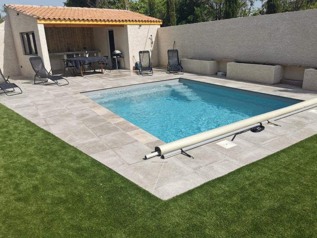 - une grande piscine dans une cour avec gazon dans l'établissement Villa calme piscine proche mer petite salle cinéma, à Montagnac