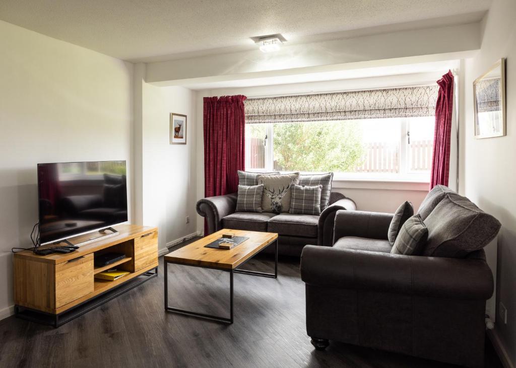 a living room with two couches and a television at Cuan - Luxury accommodation, Balivanich, Benbecula in Balivanich