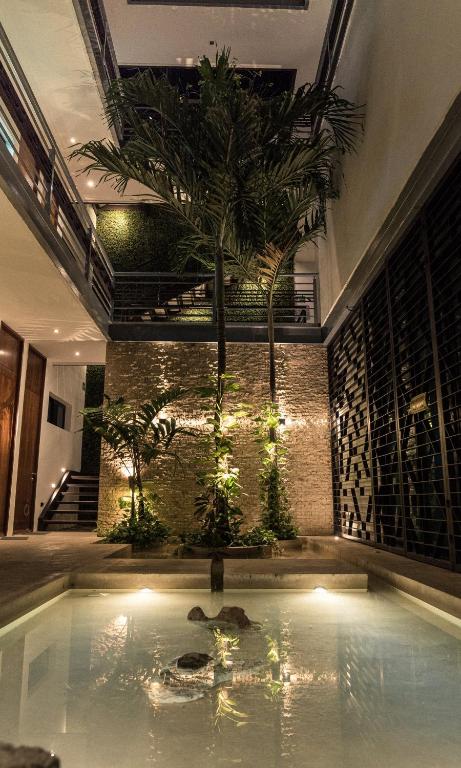 a indoor pool with a palm tree in a building at Hotel Boutique Zoren in Tulum