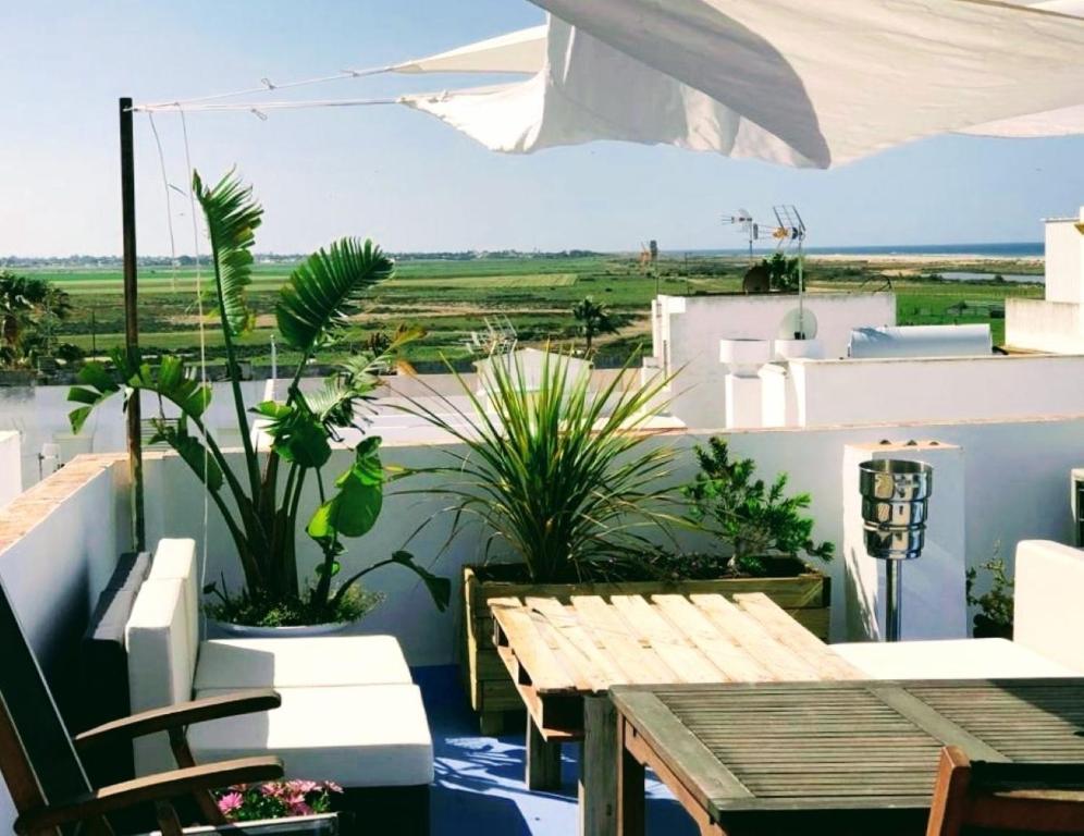 a balcony with a wooden table and chairs and a view at ABA DALÍ in Conil de la Frontera