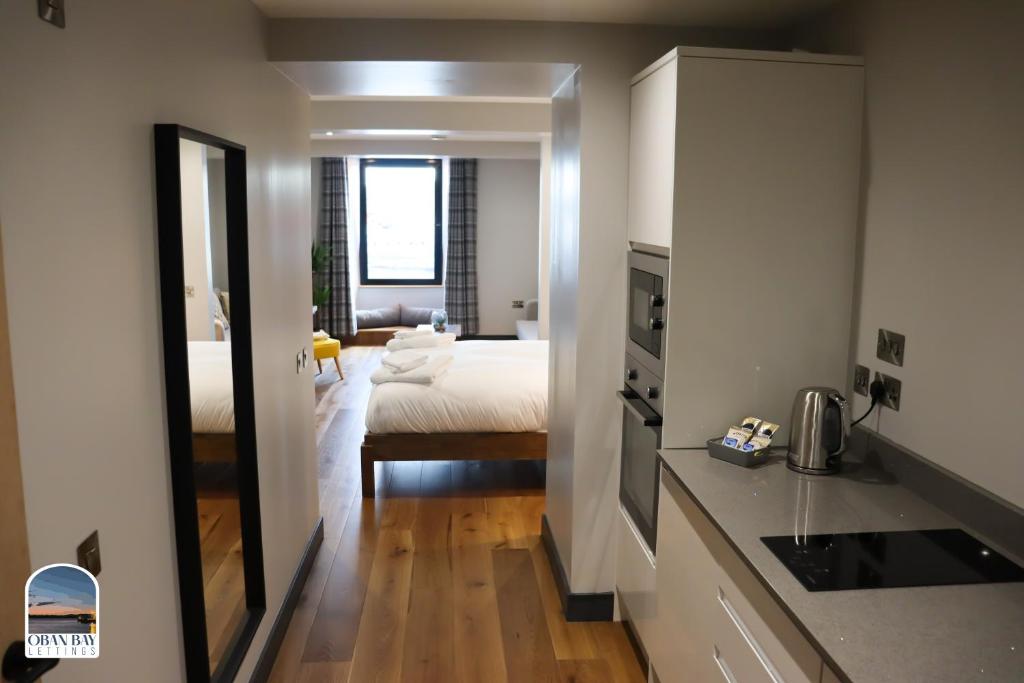 une cuisine et une chambre avec un lit dans une pièce dans l'établissement Oban Bay Apartments, à Oban