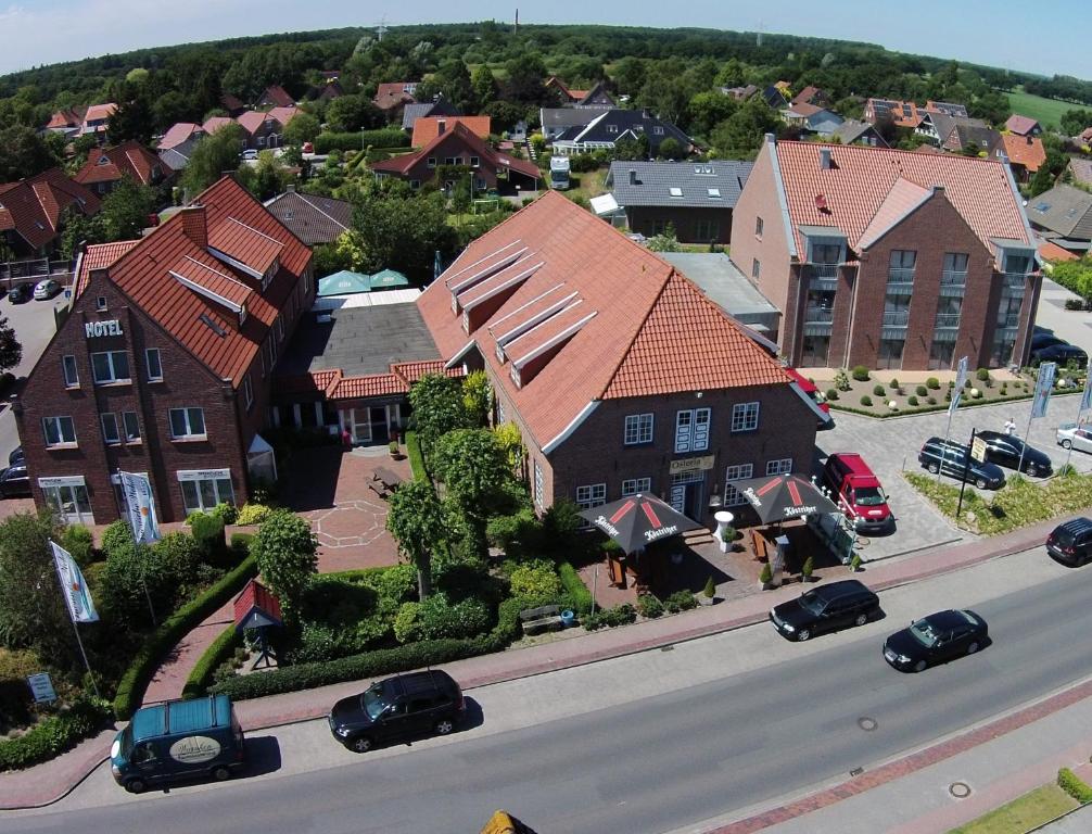 ein Modell eines Hauses mit Autos, die auf einer Straße geparkt sind in der Unterkunft Hotel Friesische Wehde in Bockhorn