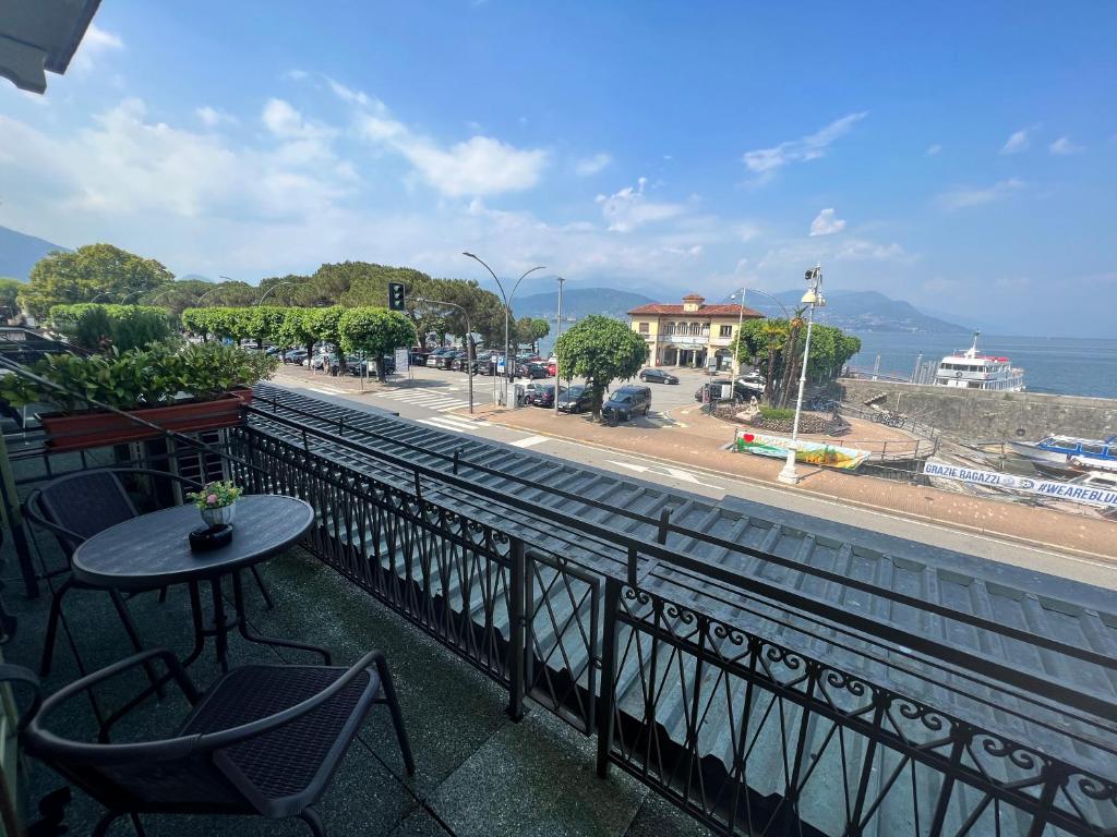 a balcony with a table and chairs and a view of a street at Appartamento miralago in Stresa