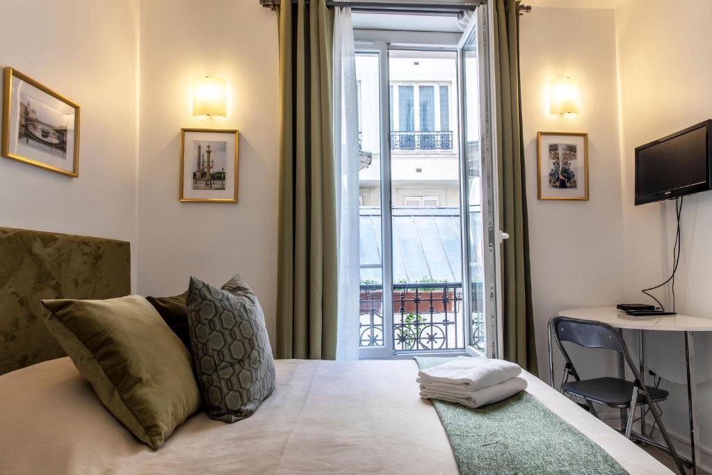 a bedroom with a bed and a window with a view at Montmartre Apartments Chagall in Paris