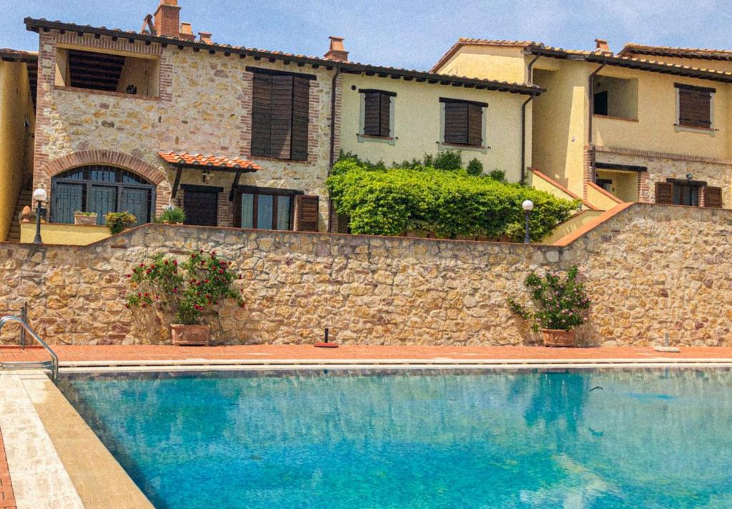 ein Haus mit einem Pool vor einem Gebäude in der Unterkunft UMBRIA, "Casa Sagrantina" con PISCINA e pergolato in Collazzone