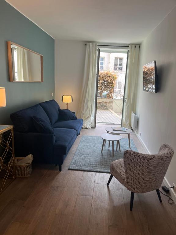 a living room with a blue couch and a table at STUDIO HYPER CENTRE SAINT GERMAIN EN LAYE in Saint-Germain-en-Laye