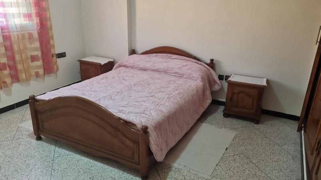 um quarto com uma cama e duas mesas de cabeceira em appartement centre kenitra em Kenitra