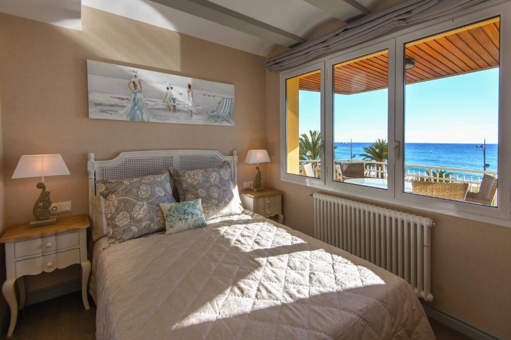a bedroom with a bed with a view of the ocean at Apartamento Marina in Lloret de Mar