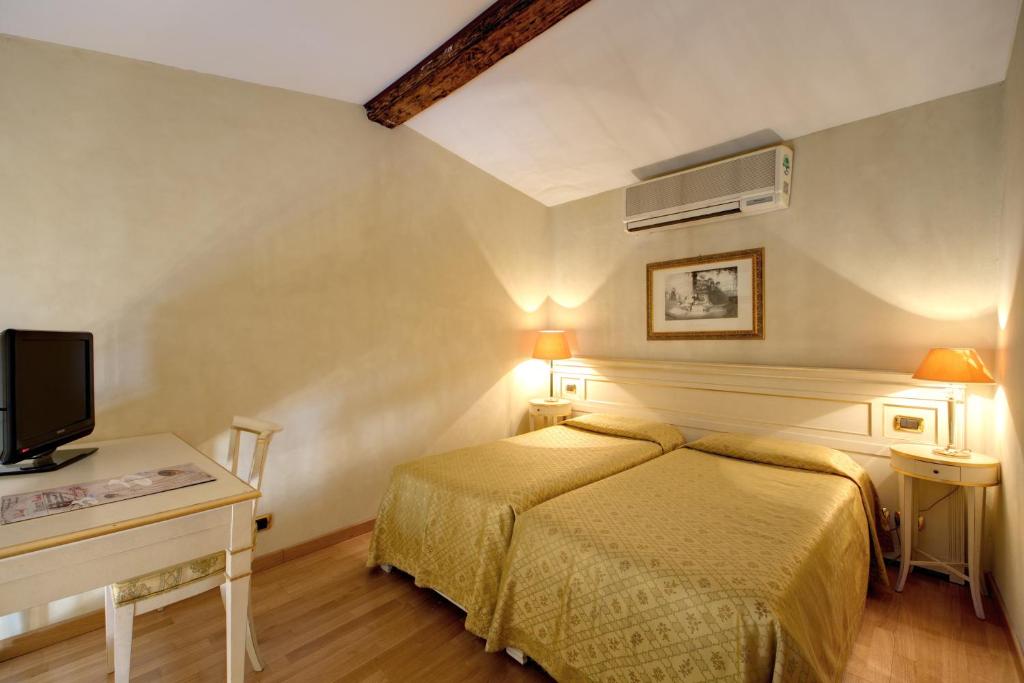 Postel nebo postele na pokoji v ubytování Hotel Bigallo