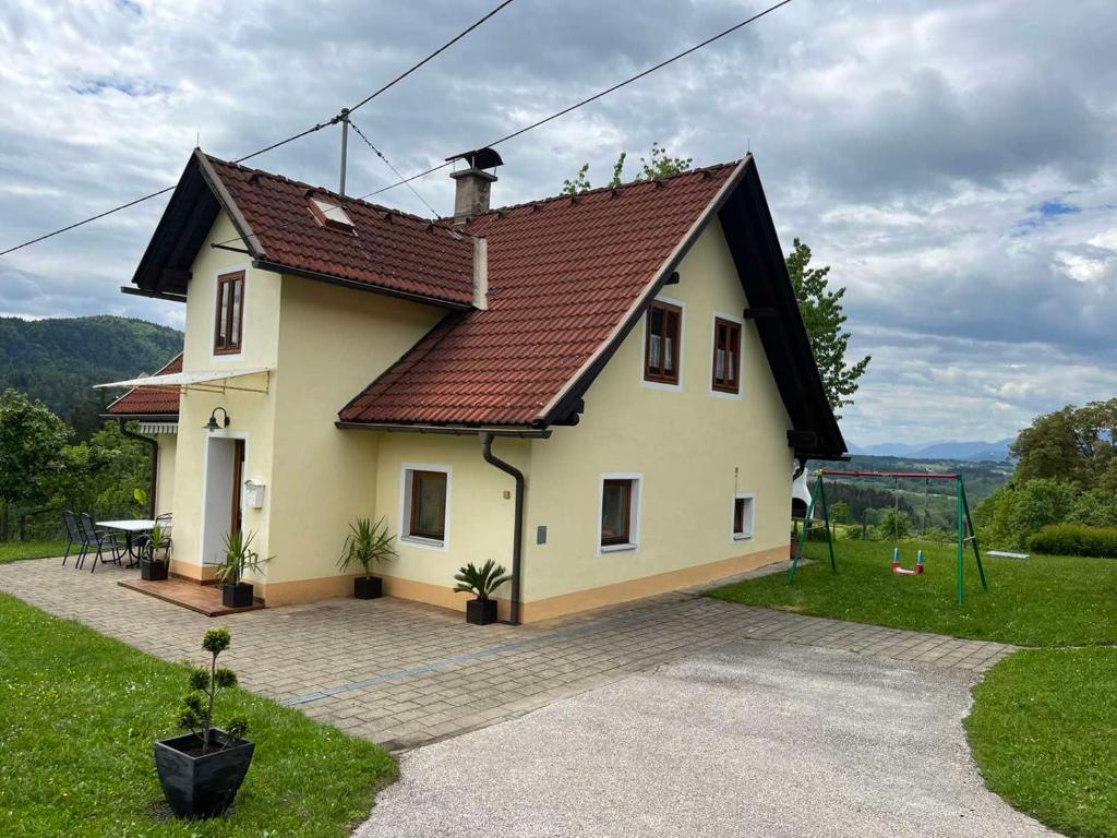 una piccola casa bianca con tetto marrone di Charmantes Ferienhaus in bester Lage a Keutschach am See