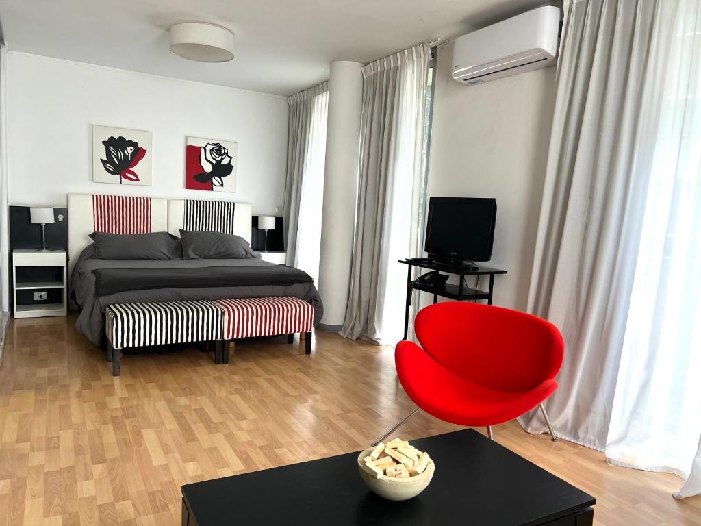 a bedroom with a bed and a red chair at Apartamentos Libertador, Martinez in Martínez