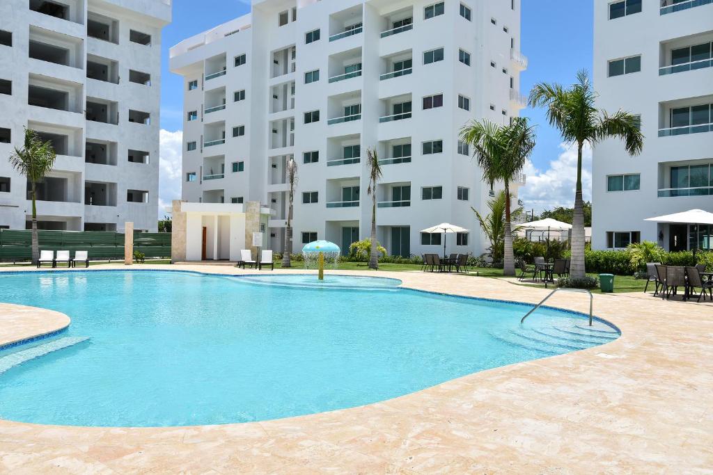 a large swimming pool in front of a building at Apartamento Juan Dolio Tepuy 701 in Juan Pedro