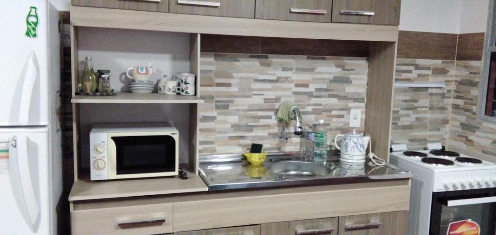 a small kitchen with a sink and a microwave at La Baquiana in Mercedes