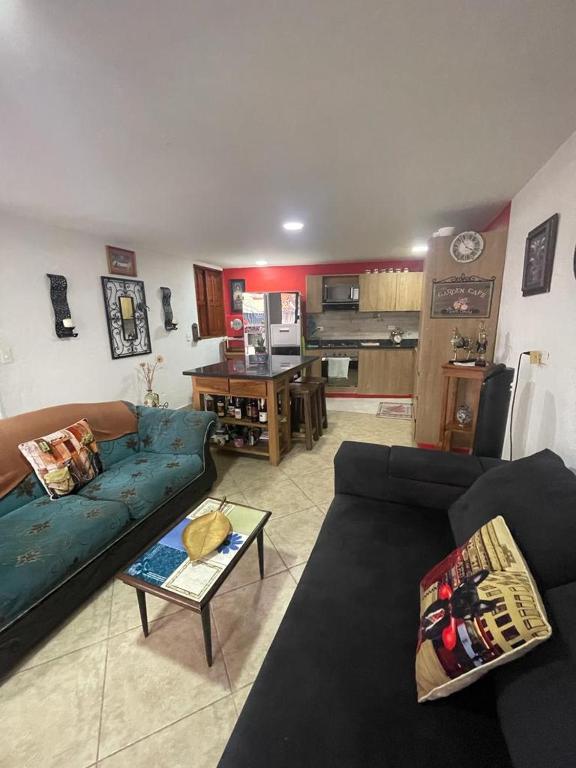 salon z dwiema kanapami i kuchnią w obiekcie Villa Chela, Hermosa casa de descanso, Venecia Antioquia w mieście Venecia