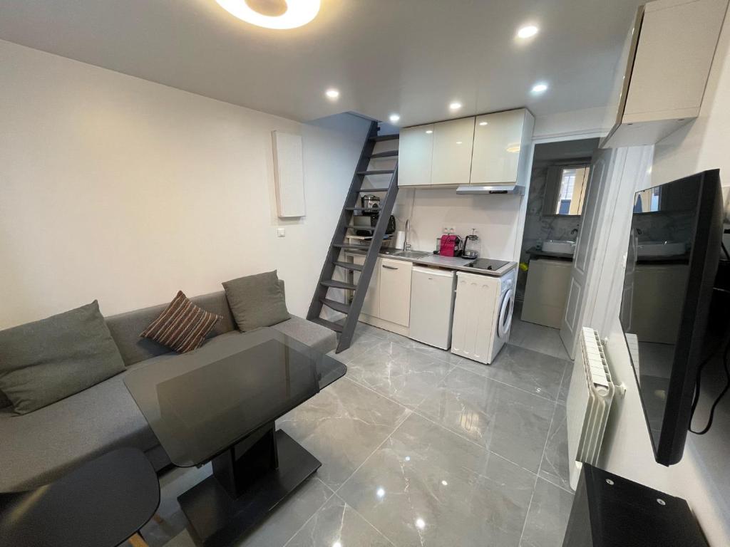 uma sala de estar com um sofá e uma cozinha em Maisonette de 25m2 à la porte de Paris em Gentilly