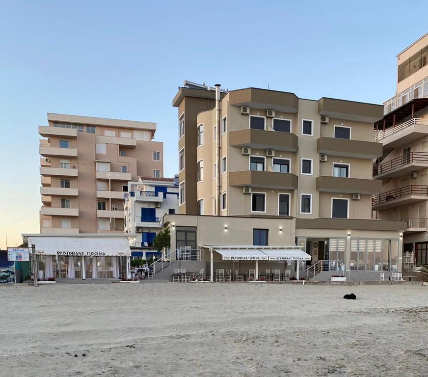 a large building on the beach in front of a building at Hotel Tirona in Durrës