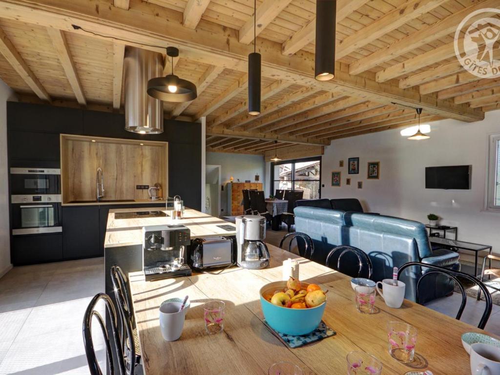 a kitchen with a table with a bowl of fruit on it at Gîte Saint-Just-Saint-Rambert, 5 pièces, 8 personnes - FR-1-496-195 in Saint-Just-Saint-Rambert