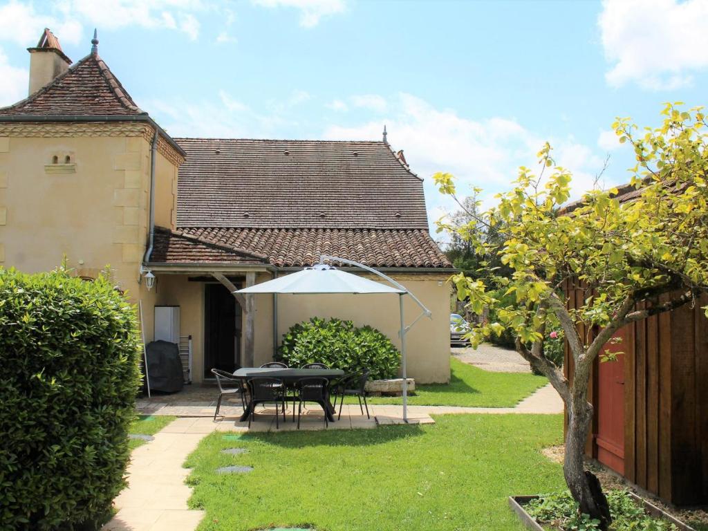 a patio with a table and an umbrella in a yard at Maison à Lamonzie-Saint-Martin avec Piscine et Animaux admis - FR-1-616-112 in Lamonzie-Saint-Martin