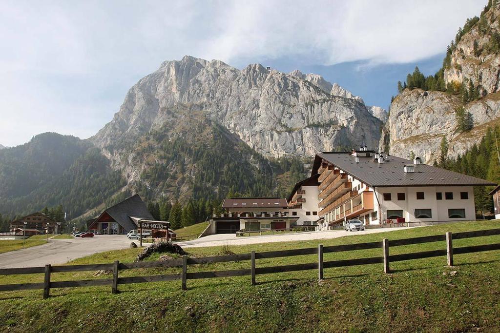 un edificio con una valla frente a una montaña en Dolomitissime Holiday Homes Marmolada, en Rocca Pietore