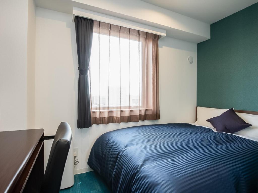Postel nebo postele na pokoji v ubytování HOTEL LiVEMAX Gifu Ekimae