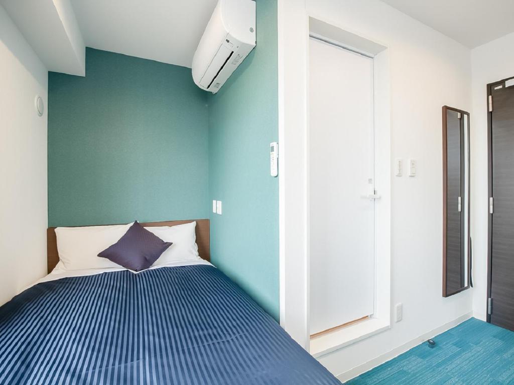 Postel nebo postele na pokoji v ubytování HOTEL LiVEMAX Gifu Ekimae