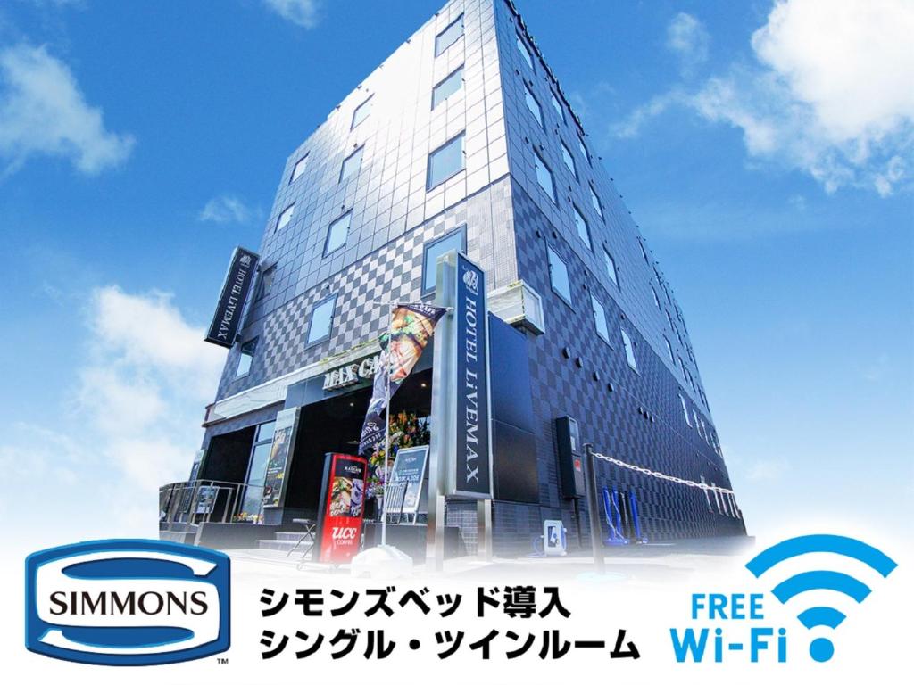 un edificio alto con un cartel delante en HOTEL LiVEMAX Gifu Hashima Ekimae, en Hashima