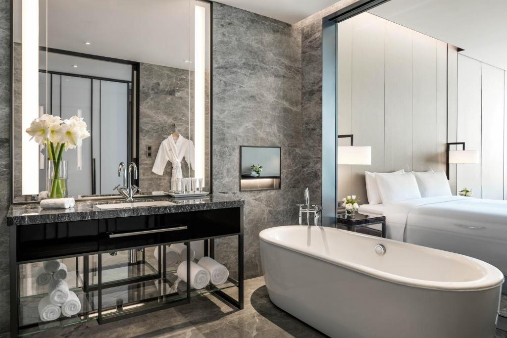 a bathroom with a tub and a bed at Niccolo Changsha in Changsha