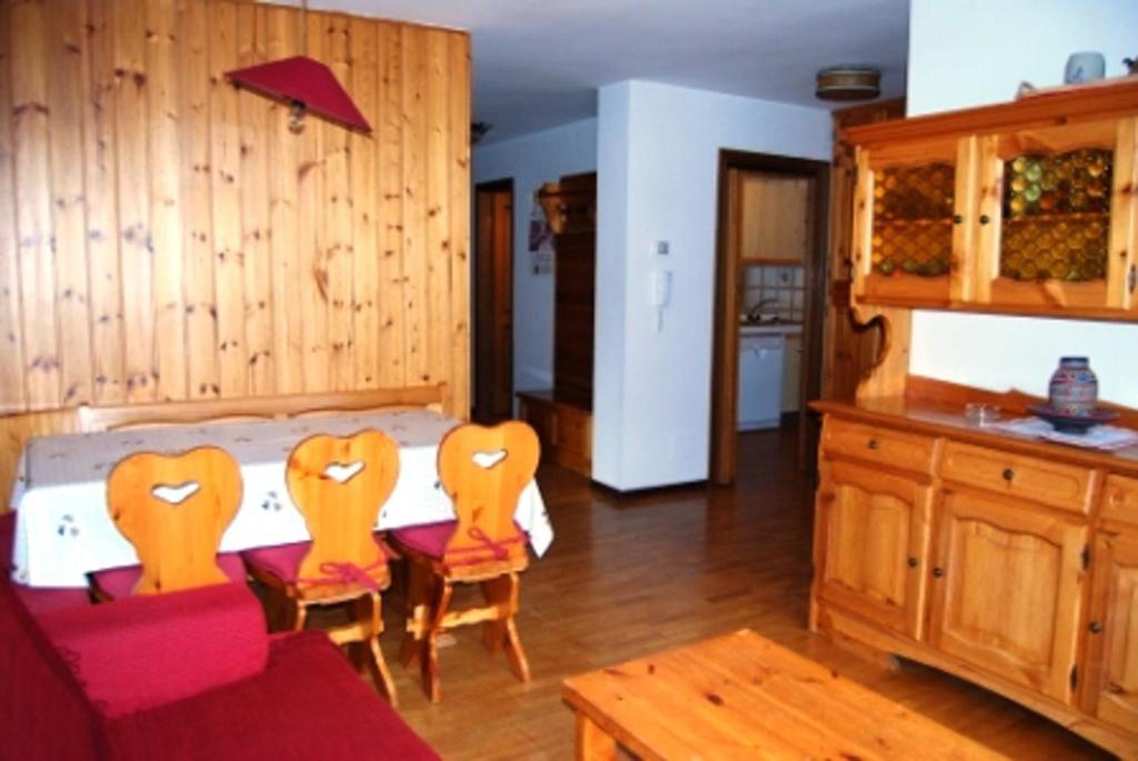 a room with a bed with chairs and a table at Campiglio Trilocale Cima Tosa in Madonna di Campiglio