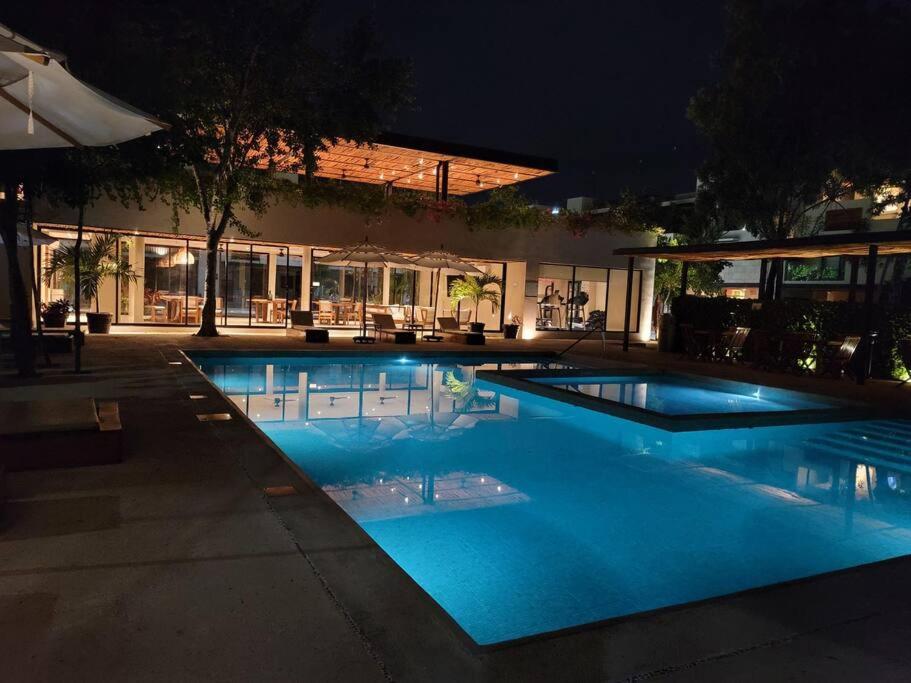 uma piscina à noite com um edifício em Amazing Dream Home in Gated Community em Playa del Carmen